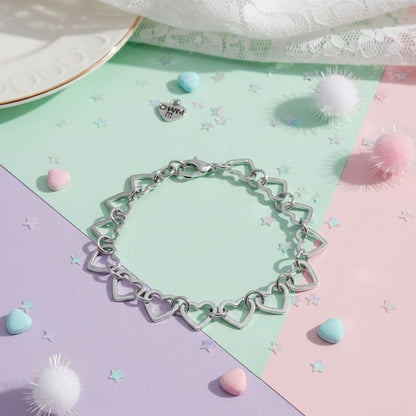 Silver heart-shaped bracelet on a colorful pastel background with decorative elements.