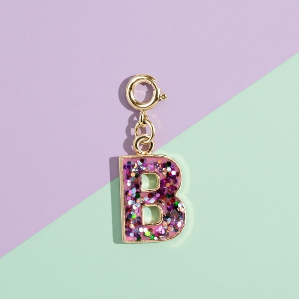 Glittery letter 'B' charm on a gold chain against a pastel background