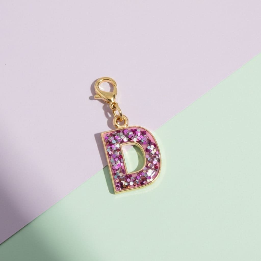 Letter 'D' charm with pink glitter on a pastel background