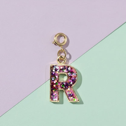 Letter 'R' charm with pink and gold accents on a pastel background