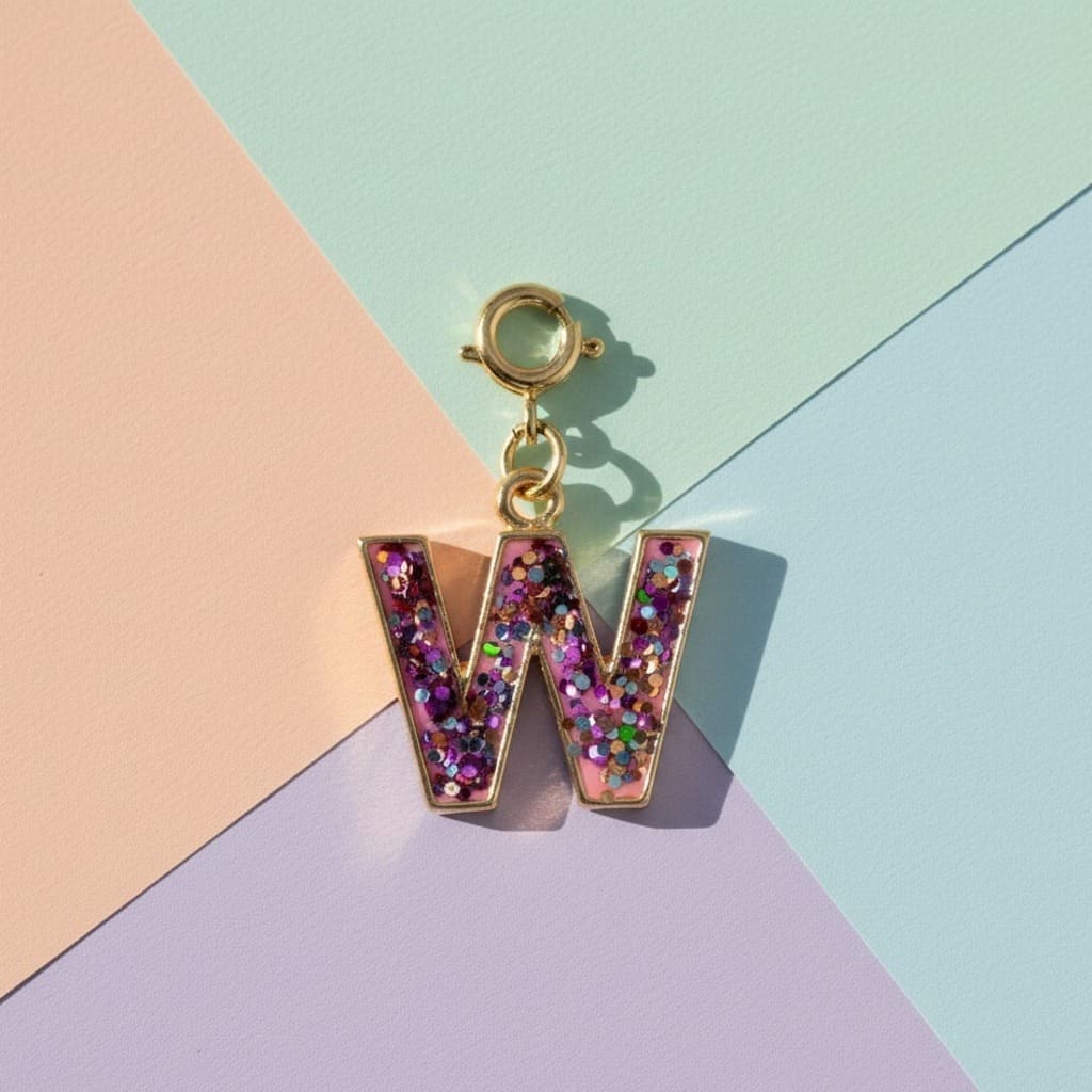Glittery letter 'W' charm on a colorful geometric background