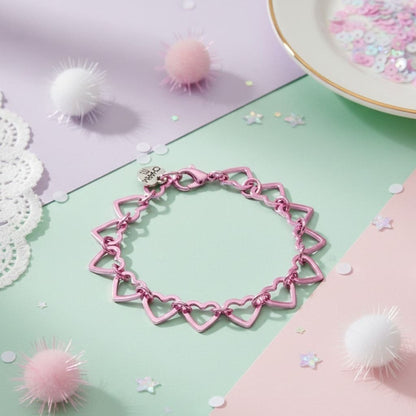 Pink heart-shaped bracelet on a pastel background with decorative elements