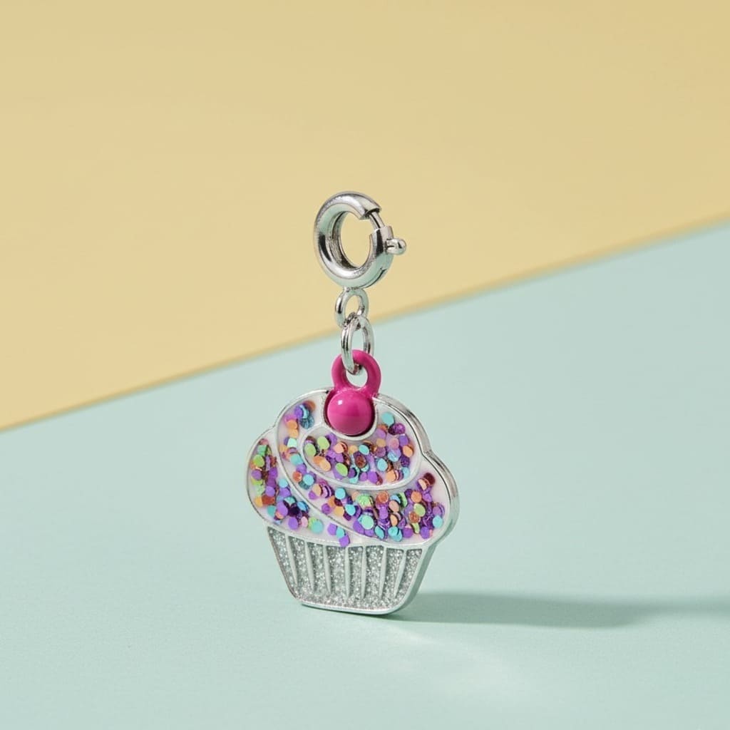 Cupcake charm with rhinestones and a pink heart on a light blue and beige background