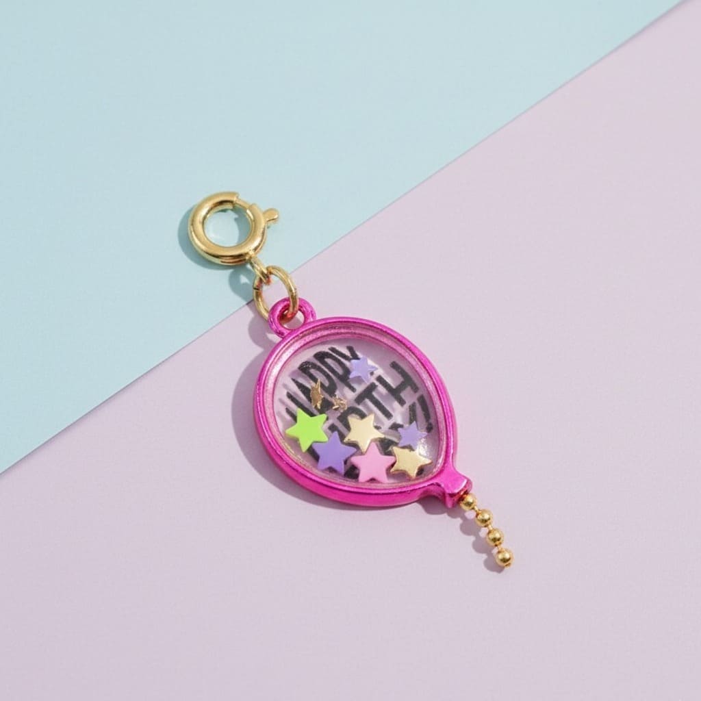 Pink locket charm with colorful stars and 'Happy Birthday' text on a pastel background