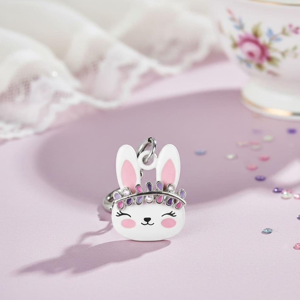 Keychain shaped like a rabbit with a tiara on a pink surface