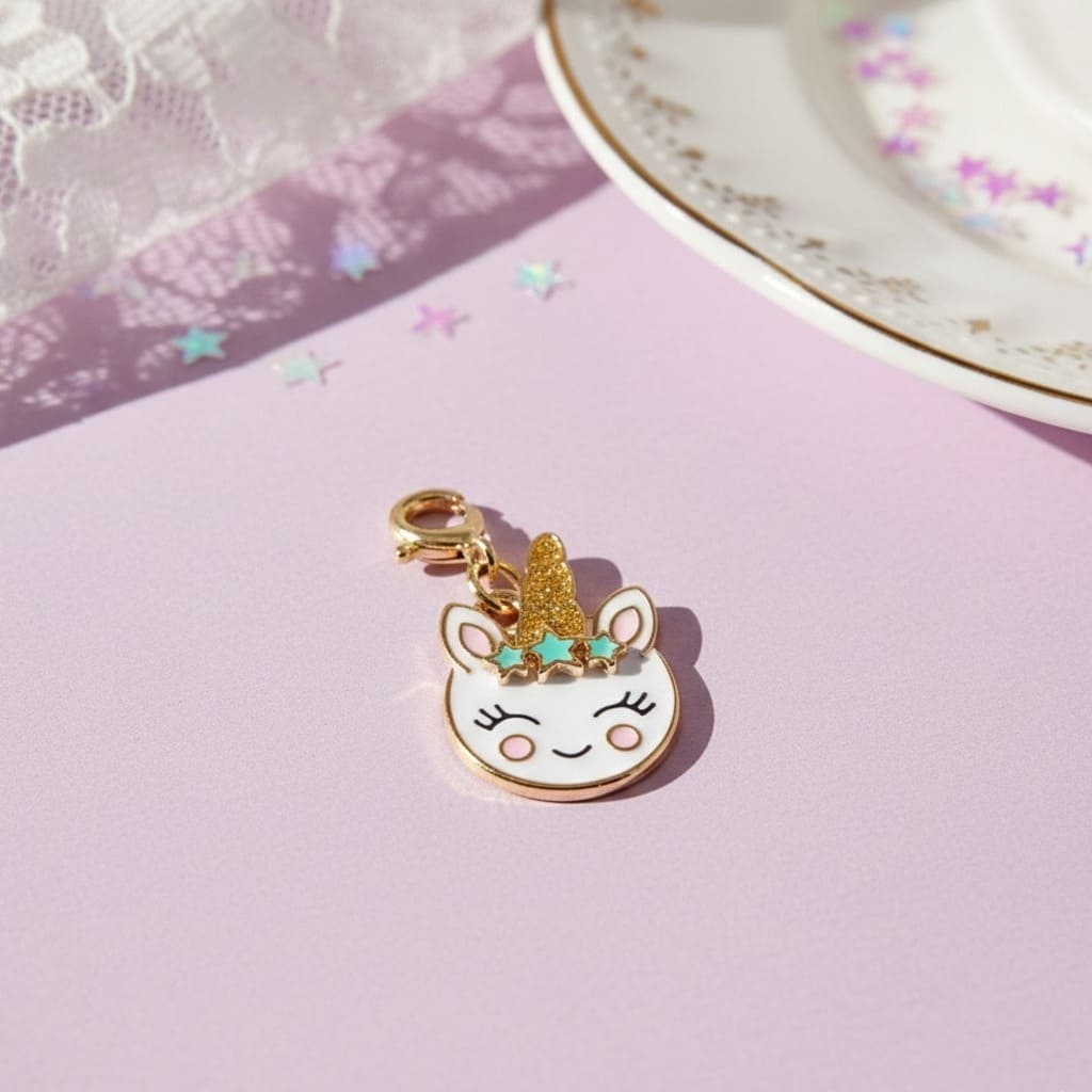 Unicorn charm with gold horn on a pink surface