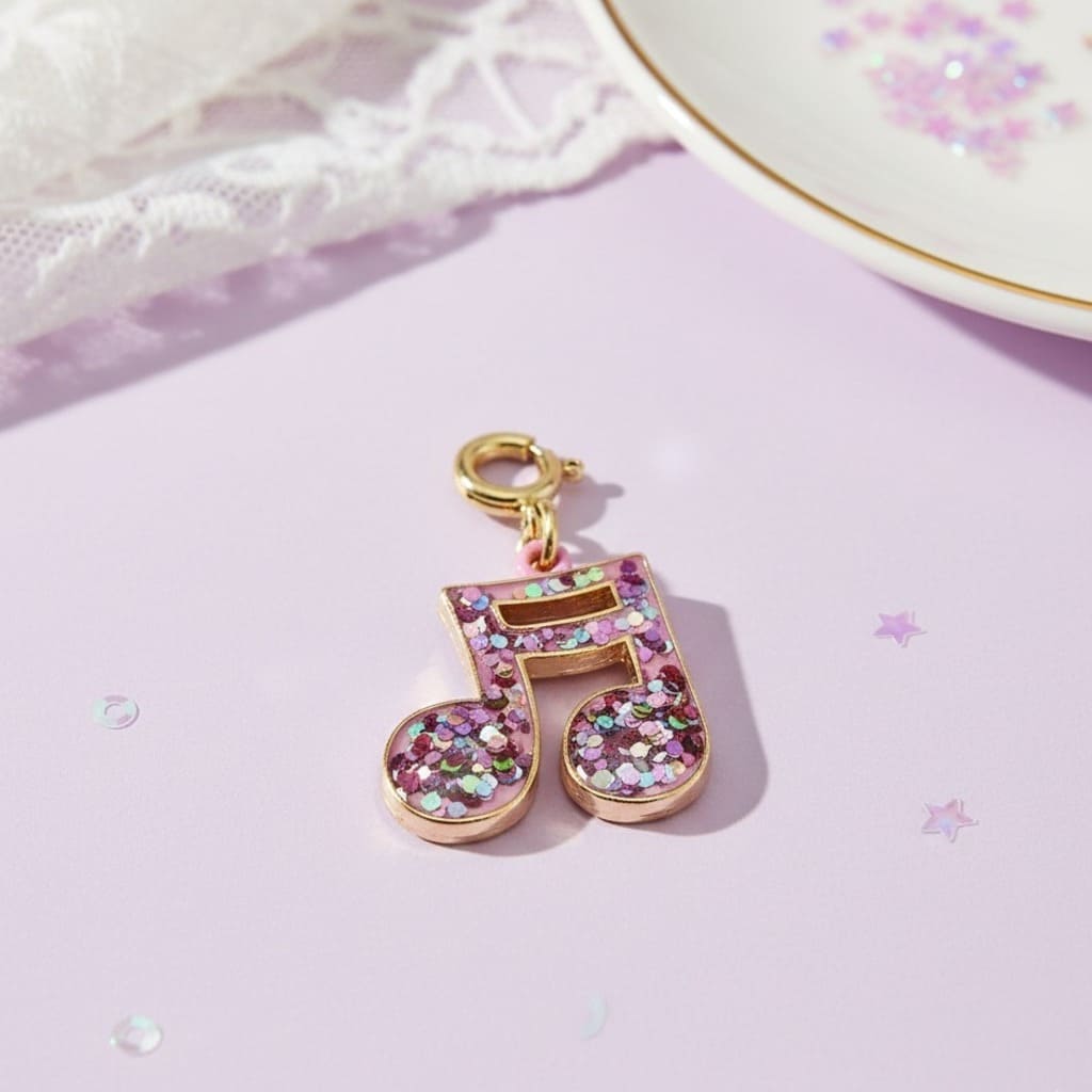 Decorative keychain with a pink musical note design on a light purple surface.