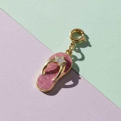 Pink glittery flip-flop charm with gold accents on a pastel background