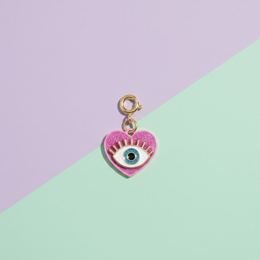 Heart-shaped charm with an eye design on a two-tone purple and green background