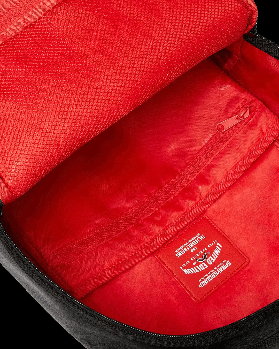 Close-up of a red bag with a visible brand logo on a black background