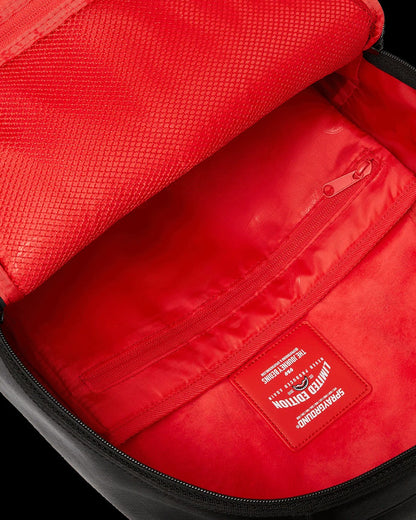 Close-up of a red bag with a visible brand logo on a black background