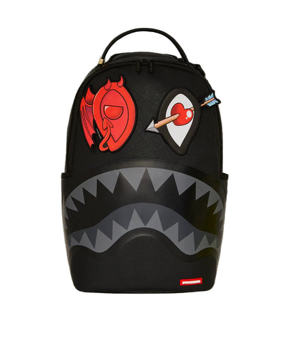 Black backpack with shark mouth design and colorful patches on a black background