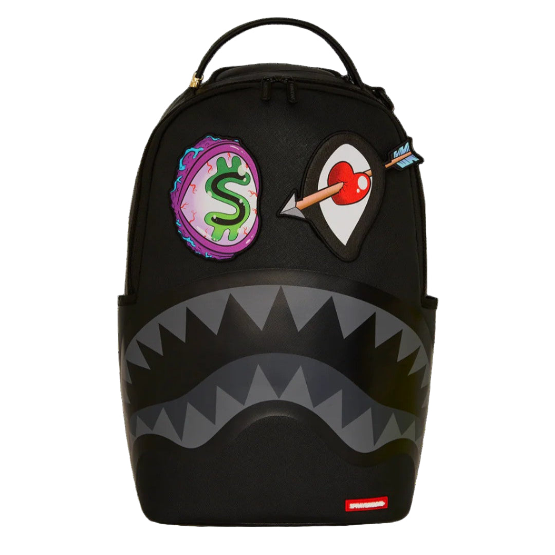 Black backpack with shark mouth design and colorful patches on a white background