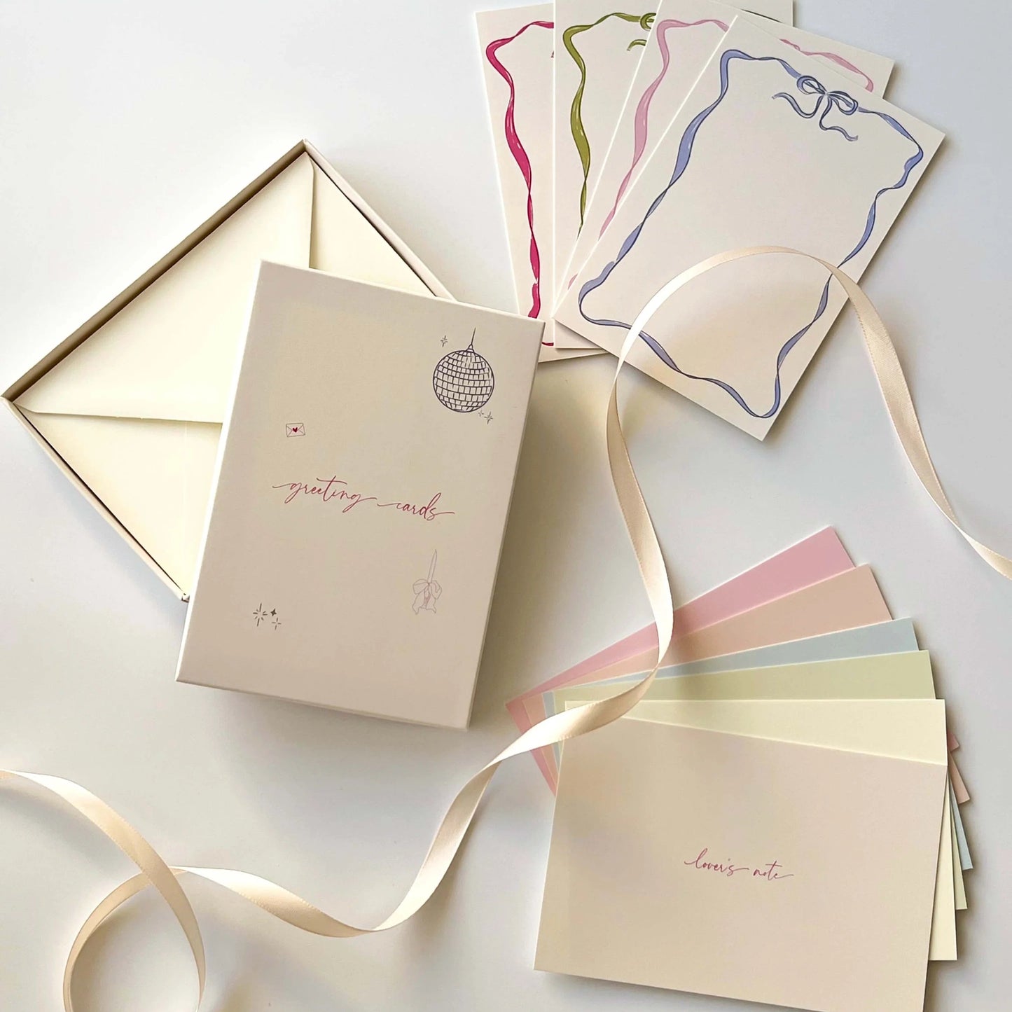 Set of greeting cards and envelopes with ribbons on a light background