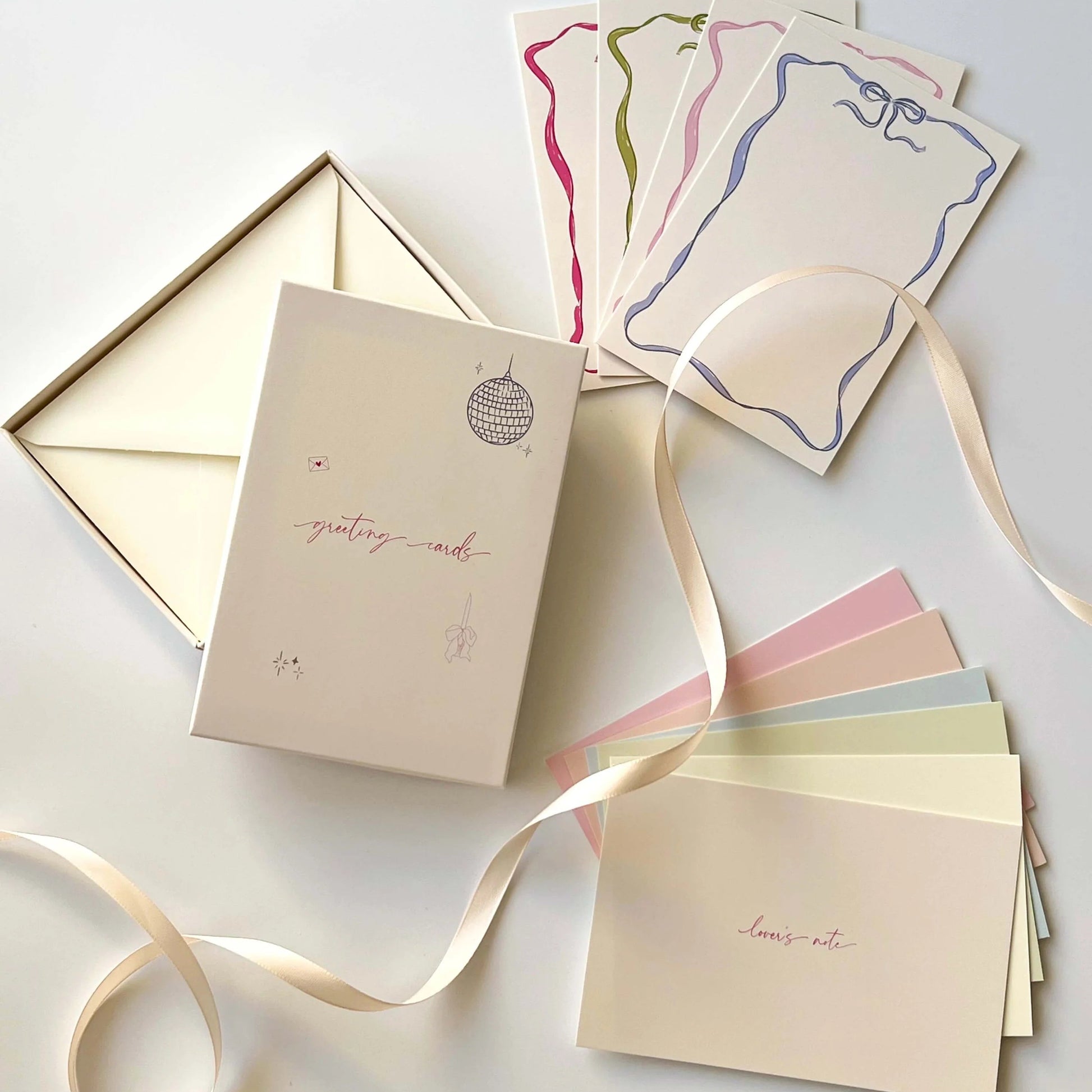 Set of greeting cards and envelopes with ribbons on a light background