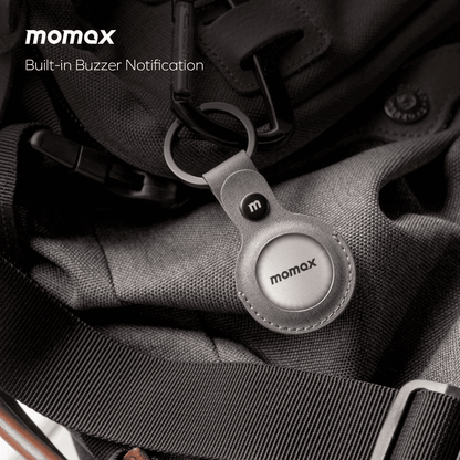 Momax keychain device on a textured surface with 'momax' branding.