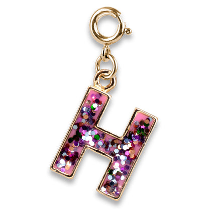 Gold charm with a pink letter 'H' filled with glitter on a white background
