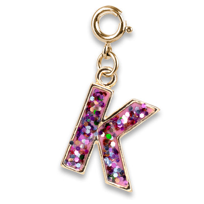 Gold charm with a pink glittery letter 'K' on a white background