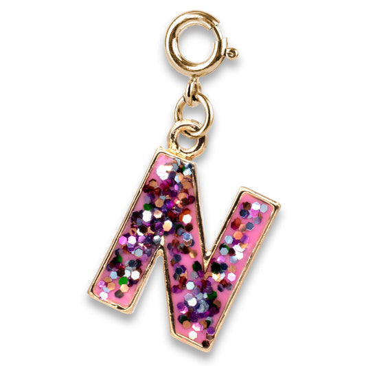 Gold charm with a pink letter 'N' filled with glitter on a white background
