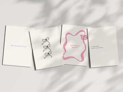 Four white greeting cards with decorative bows on a light gray background