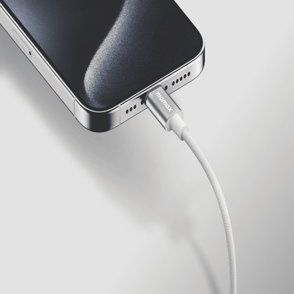 Smartphone being charged with a cable on a light gray background