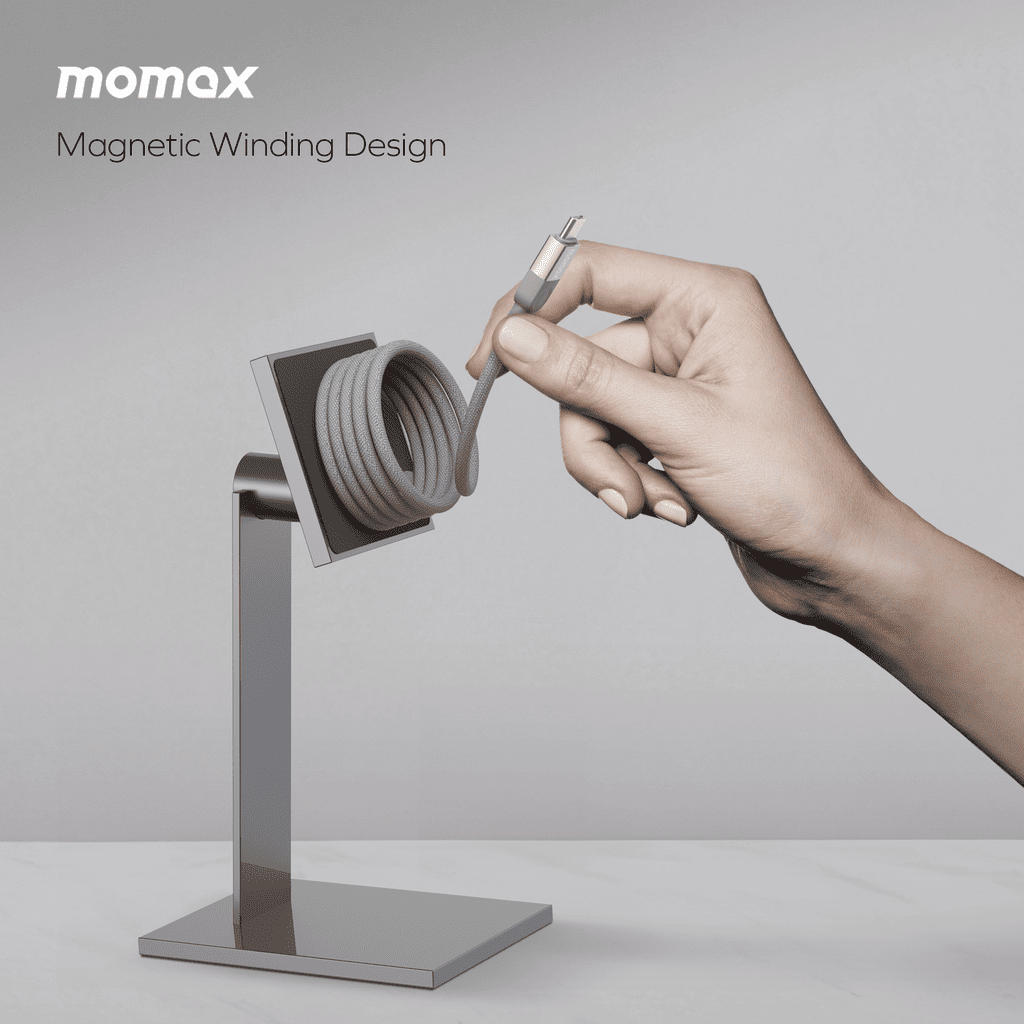 Hand interacting with a magnetic winding design product on a stand, with 'momax' branding.