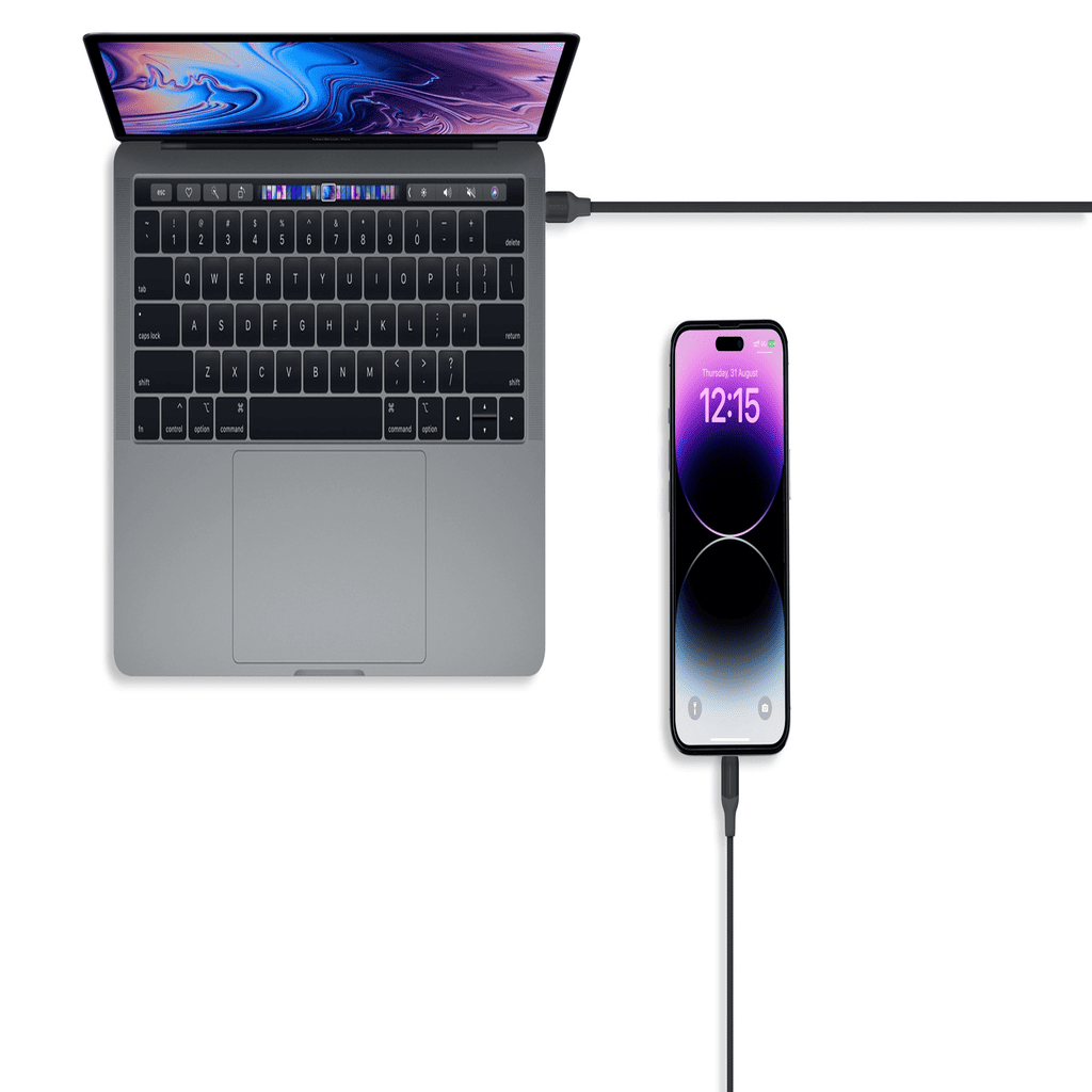 Laptop and smartphone connected by a cable on a white background