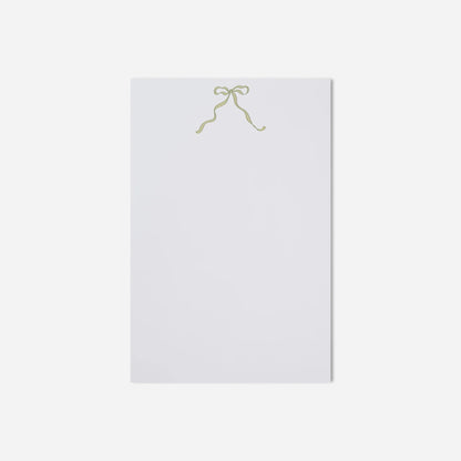 White sheet of paper with a gold bow on a white background