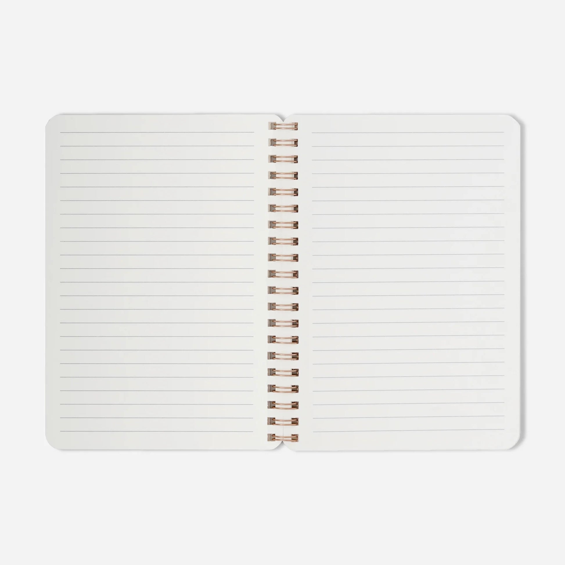 Open notebook with white pages and rose gold spiral binding on a light gray background
