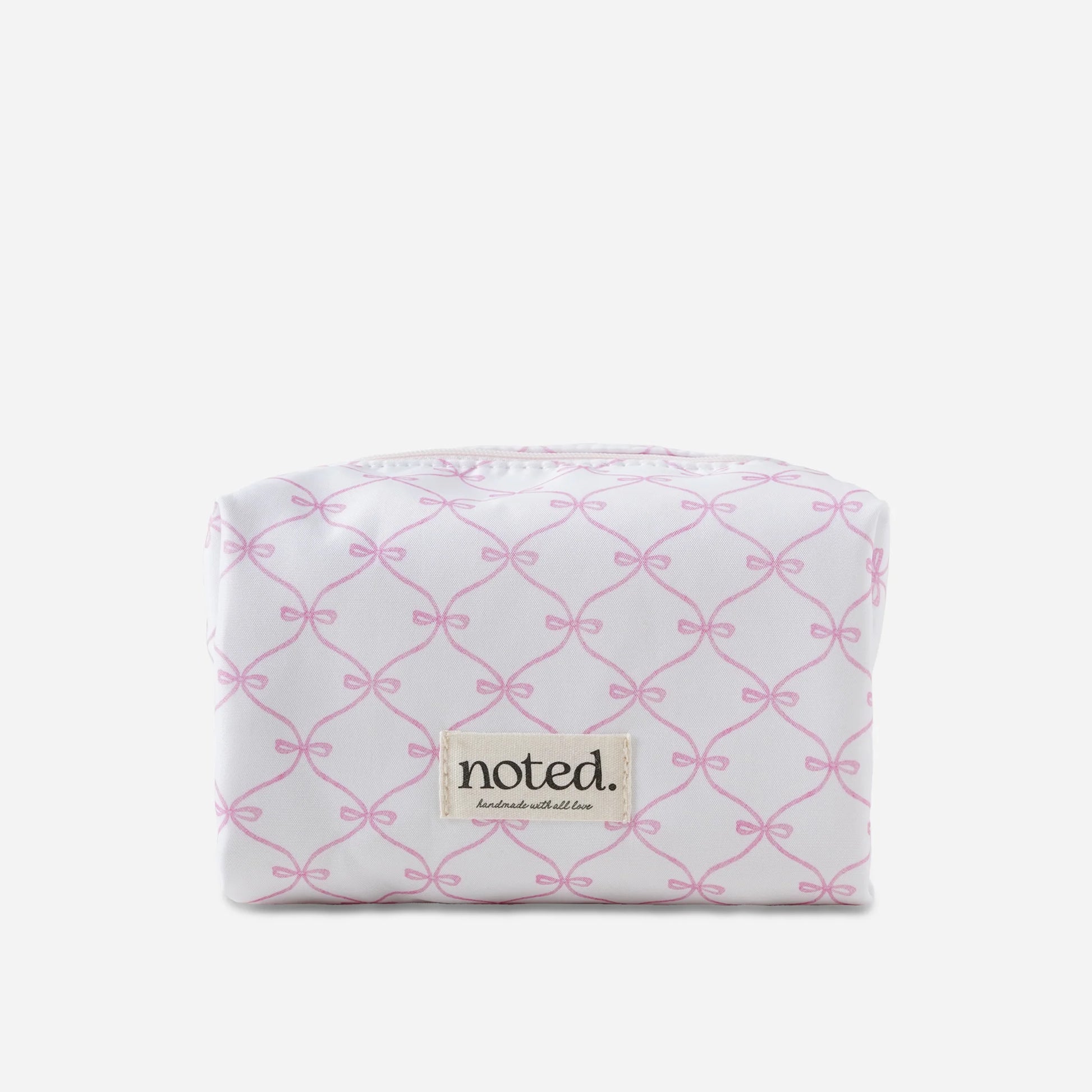 White pouch with pink bow pattern and 'noted' brand label on a white background