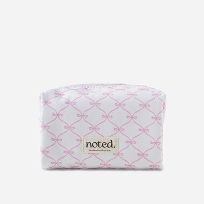 White pouch with pink bow pattern and 'noted' brand label on a white background