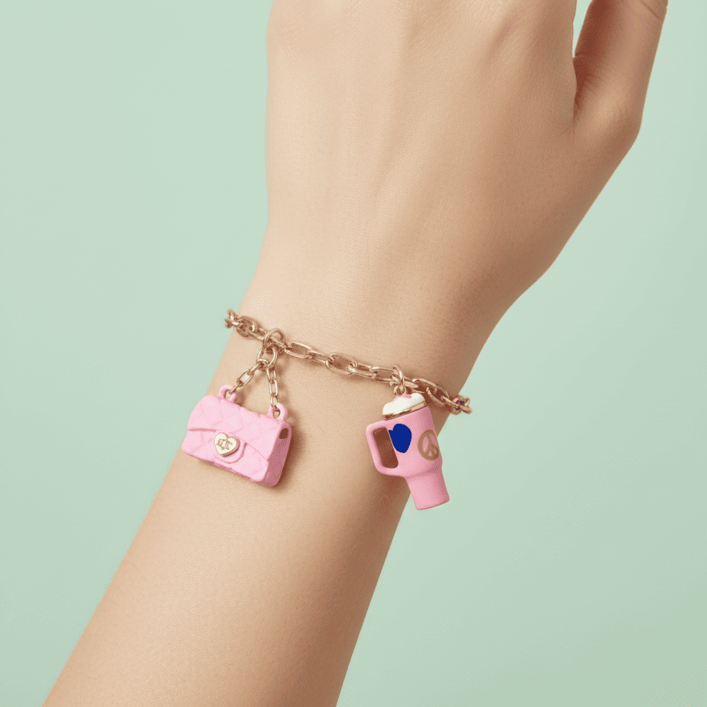 Bracelet with pink camera and cup charms on a light green background