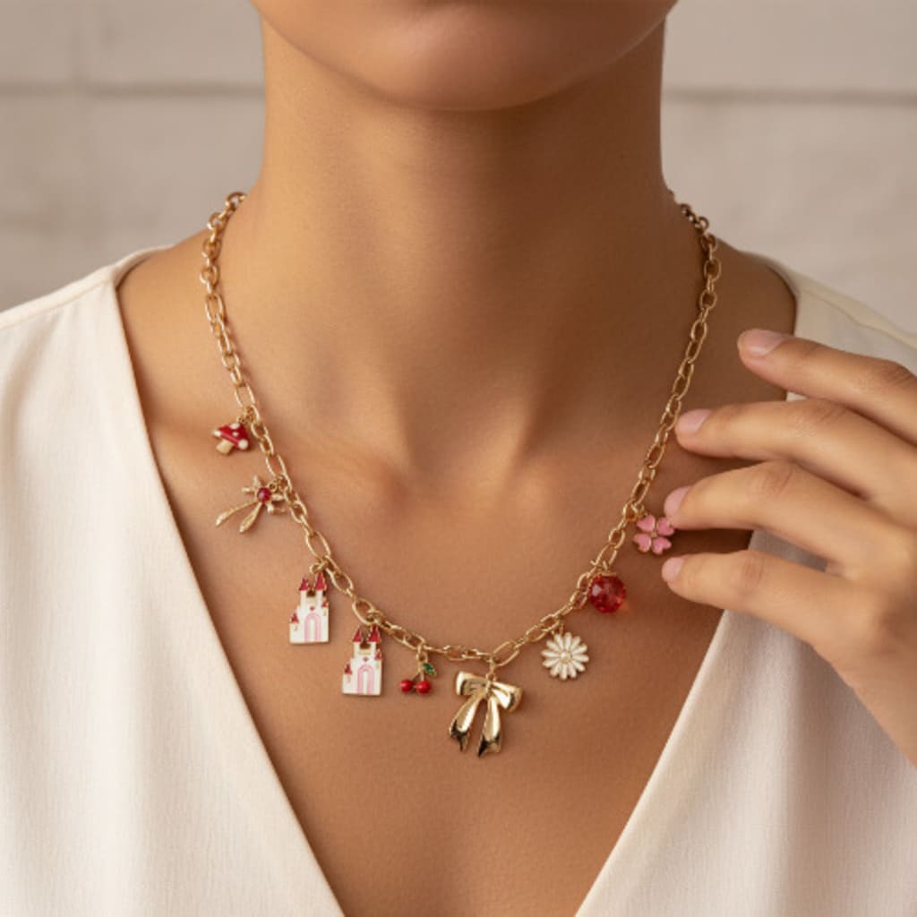 Gold necklace with charms on a mannequin wearing a white top.