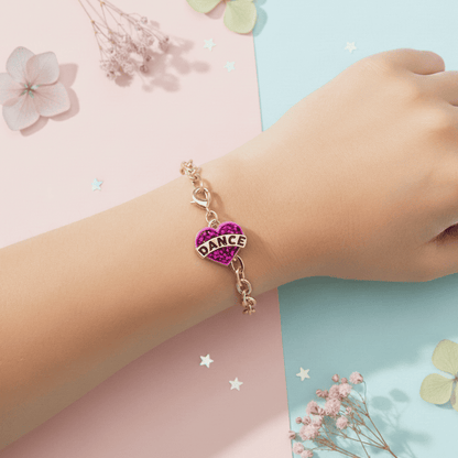 Bracelet with a purple heart charm labeled 'DANCE' on a child's wrist against a pastel background.