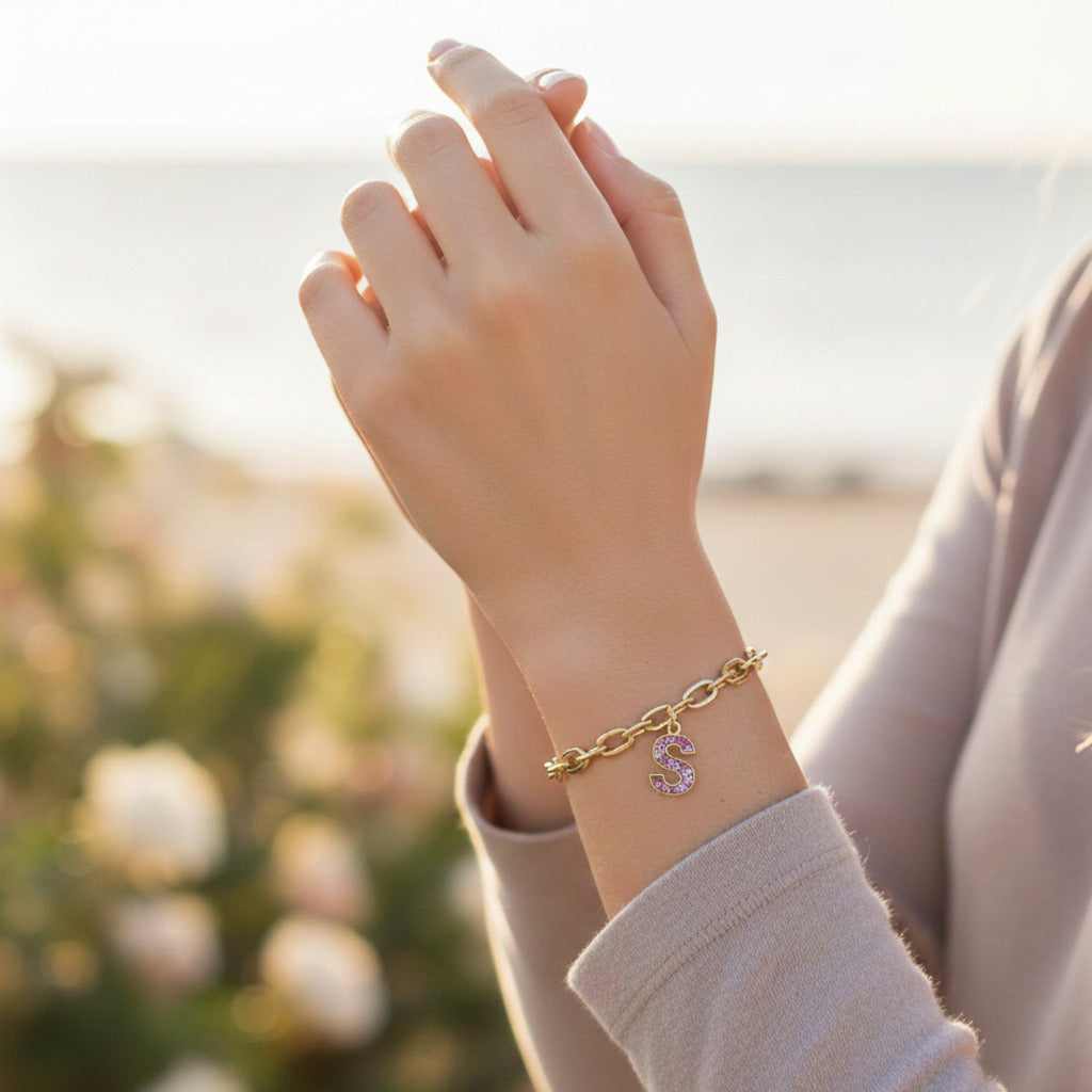 Letter S charm with gold bracelet with asthetic background
