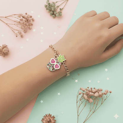 Hand wearing a colorful bracelet with floral charms on a pastel background