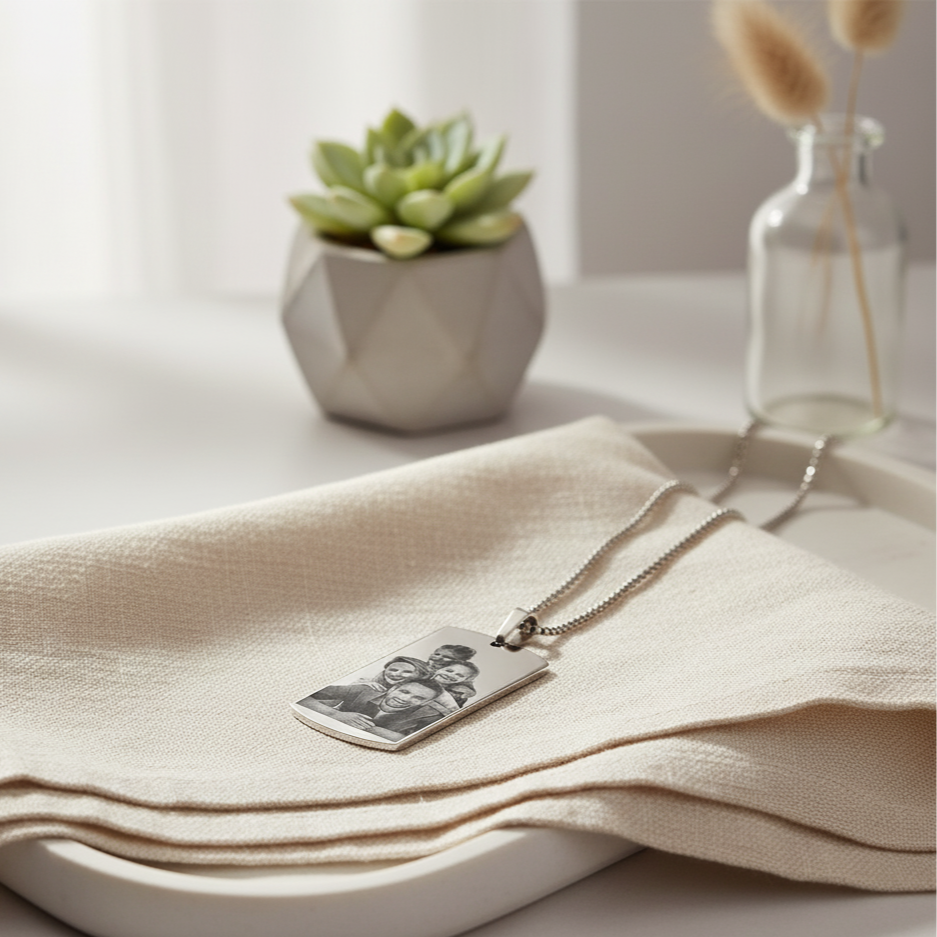 Necklace with a pendant on a beige cloth with a plant and vase in the background