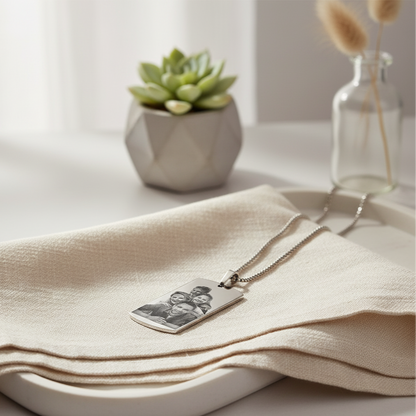 Necklace with a pendant on a beige cloth with a plant and vase in the background