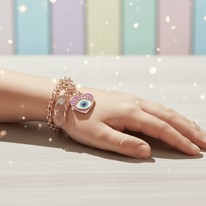 Hand wearing multiple bracelets with charms against a pastel striped background