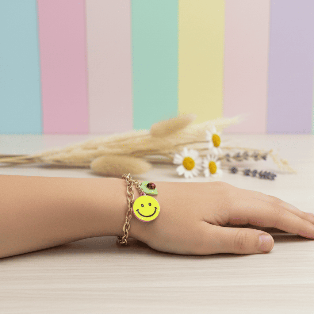 Hand wearing a bracelet with a smiley face charm against a pastel striped background