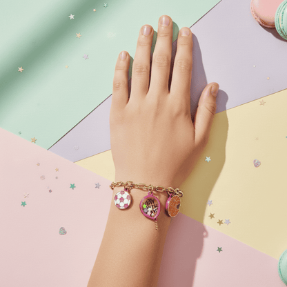Hand wearing a bracelet with charms on a colorful geometric background