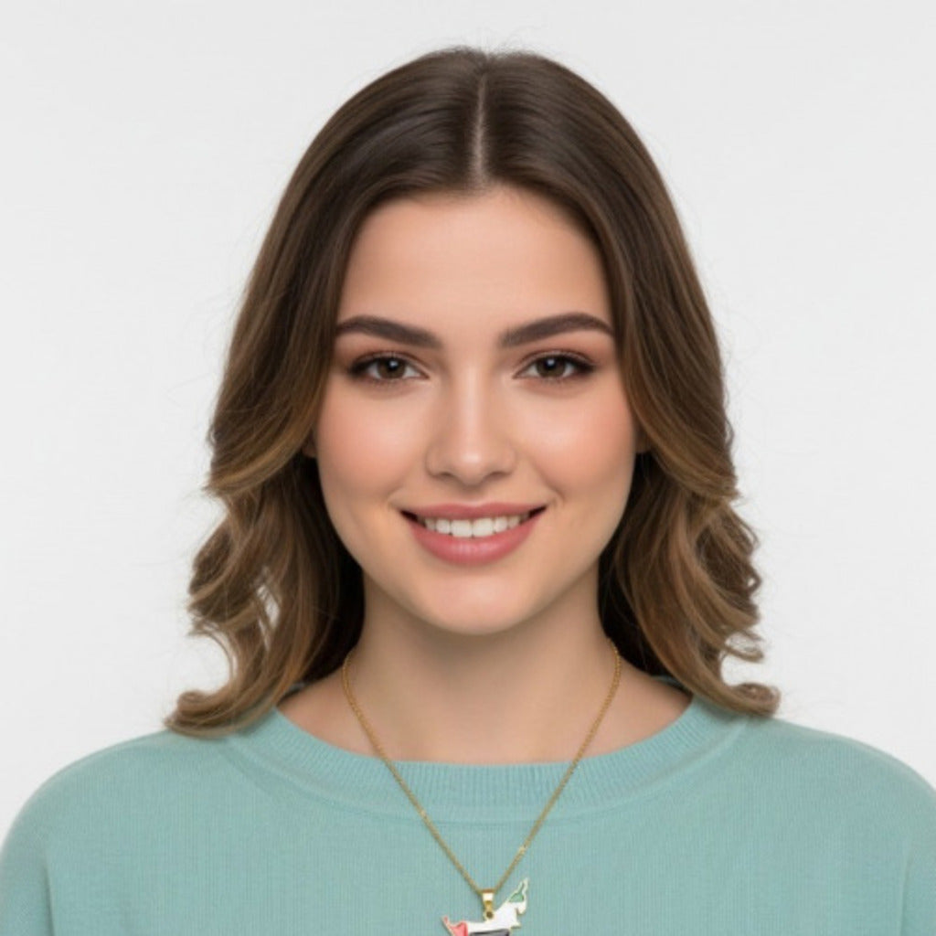 Woman wearing a light blue sweater and gold necklace against a white background