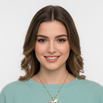 Woman wearing a light blue sweater and gold necklace against a white background