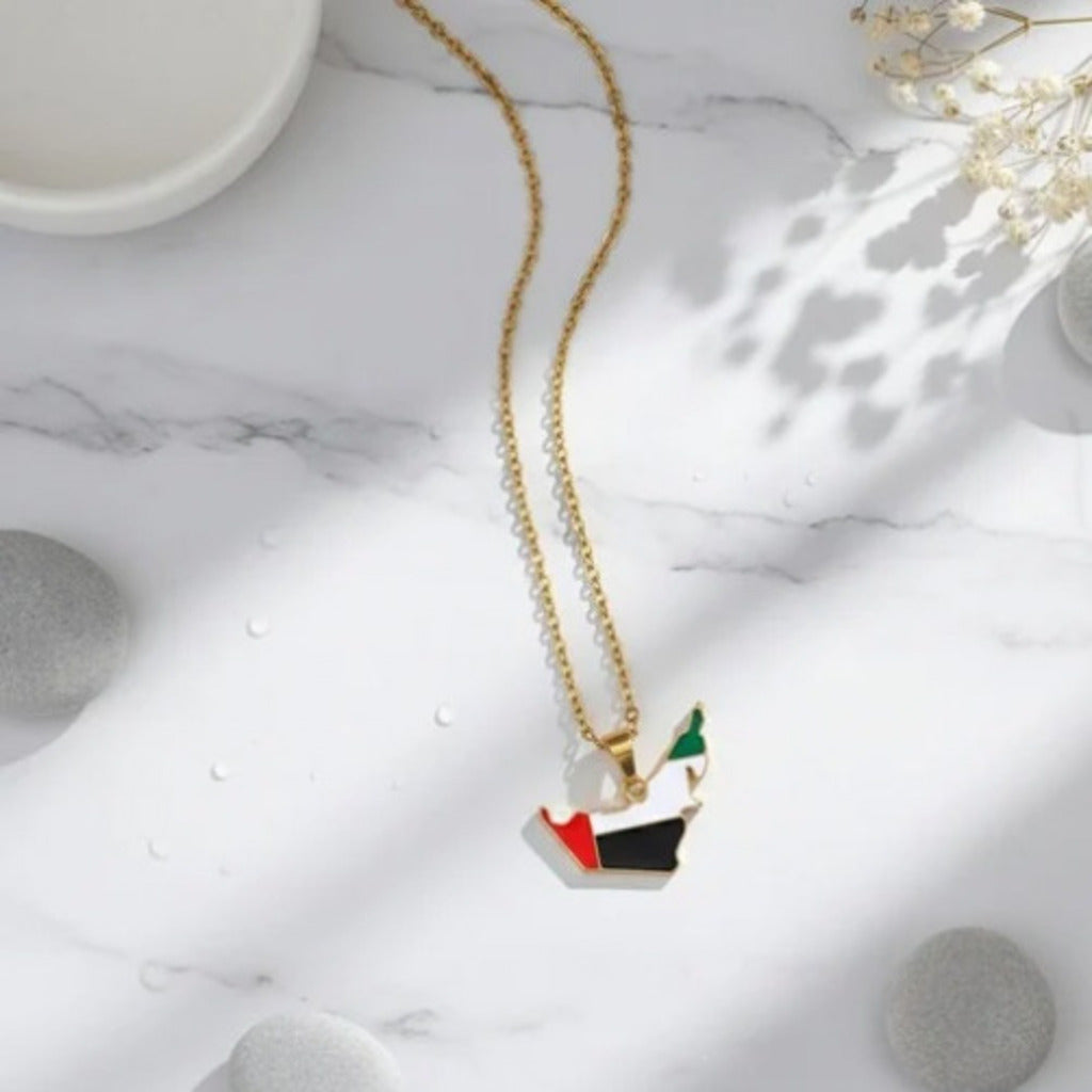 Gold necklace with a heart-shaped pendant on a marble surface