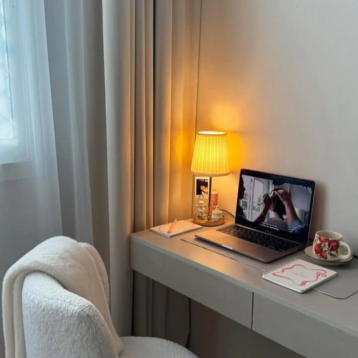 Modern home office with a desk, laptop, lamp, and chair.