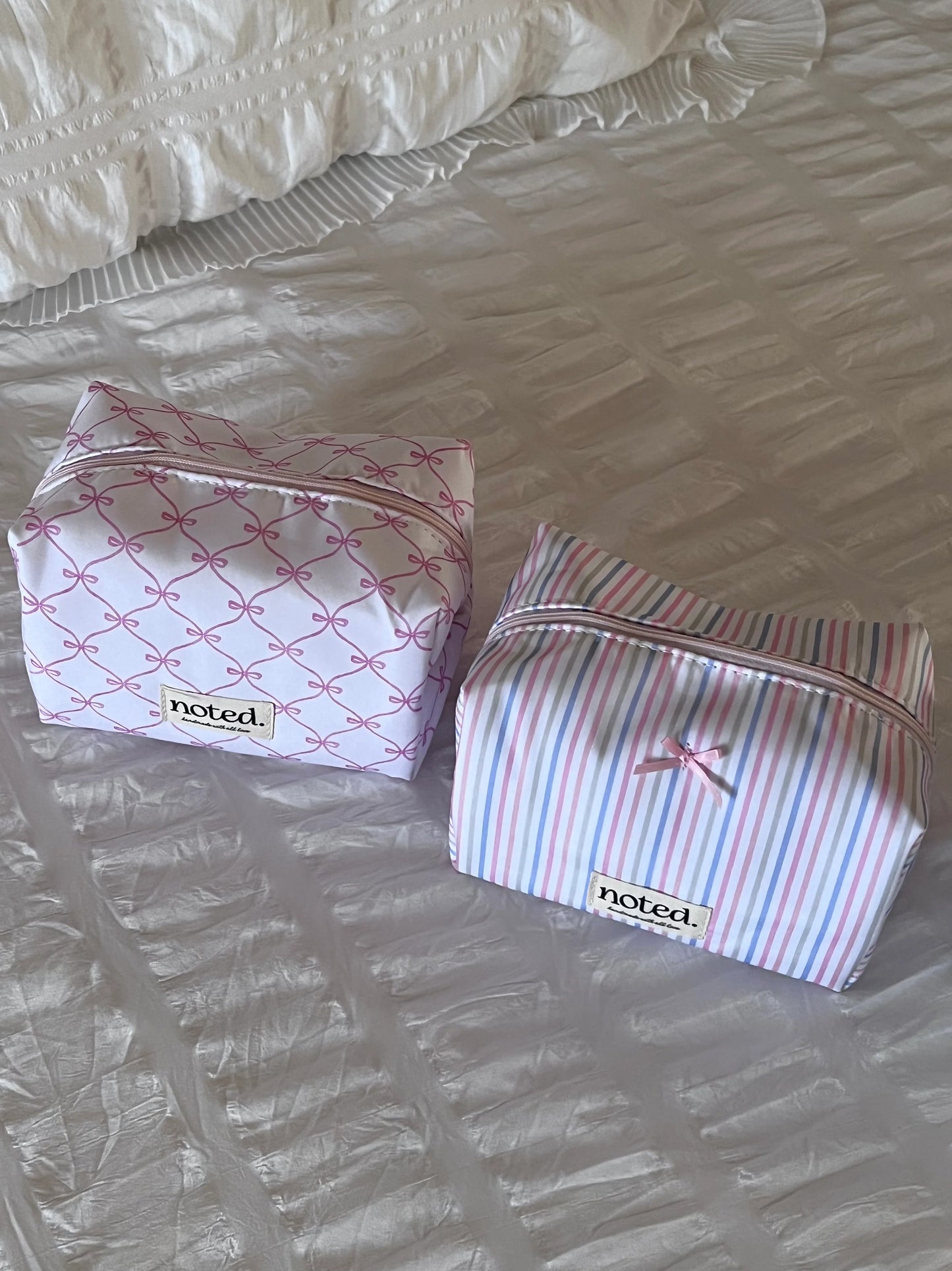 Two small bags with bow designs on a textured surface