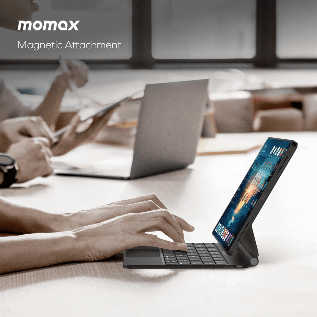 Person using a tablet with a keyboard attachment in an office setting, featuring Momax branding.