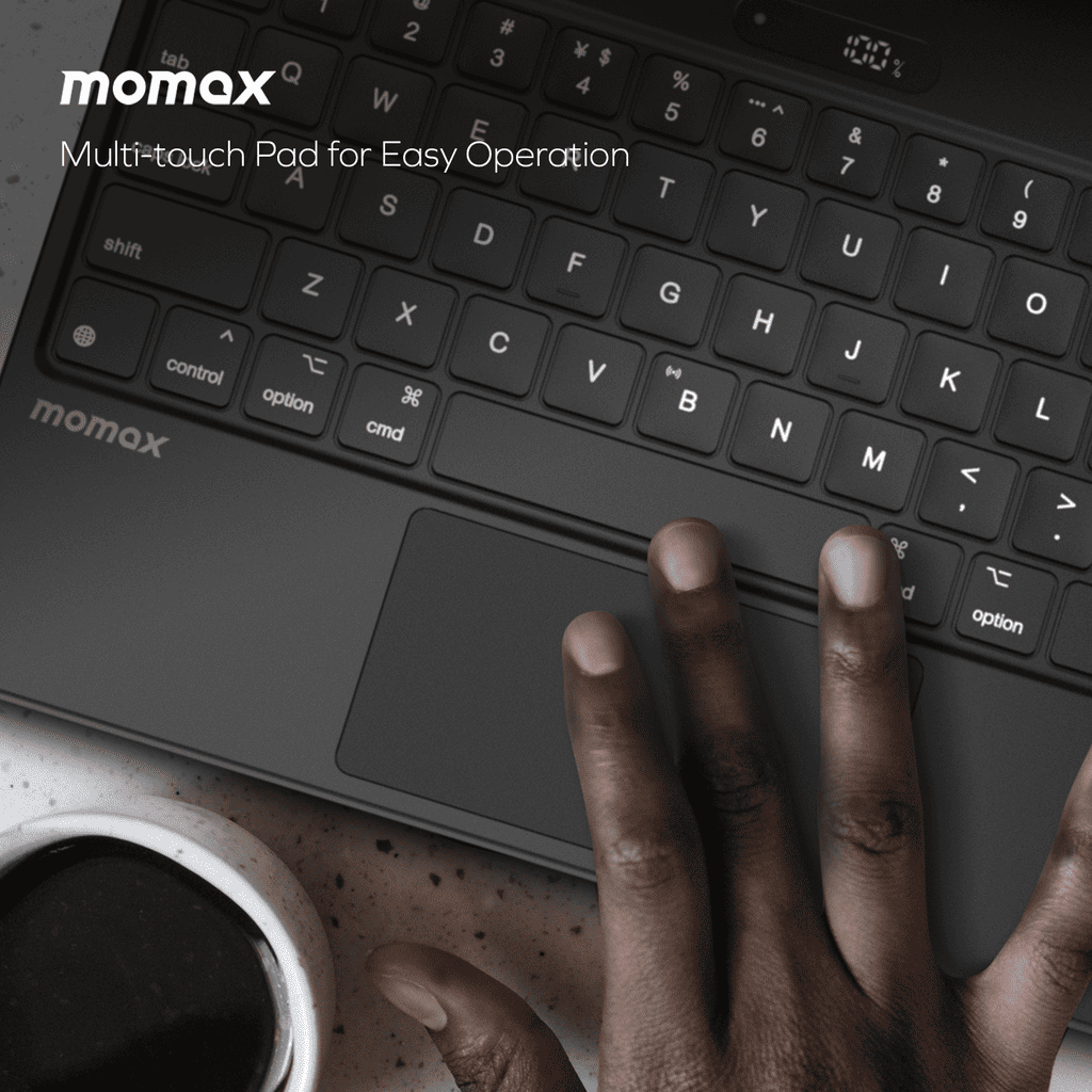 Momax multi-touch pad with keyboard and hand interacting on a dark background