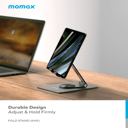 Fold stand with tablet and phone on a wooden surface, laptop in the background, Momax branding visible.