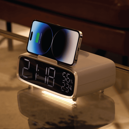 Digital clock with smartphone charging stand on a reflective surface